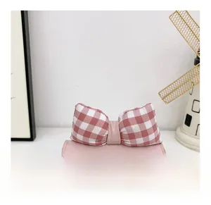 Detailed close-up of pink leather kids bag with plaid bow and cat embroidery