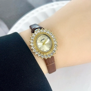 Montre à quartz dorée pour femme avec cadran ovale serti de strass et bracelet en cuir marron
