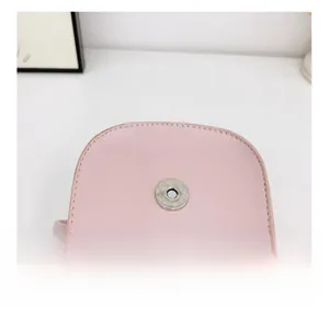 Detail shot of pink mini bag featuring a secure magnetic snap closure and fine stitching