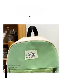 Detail of light green school backpack featuring a mountain woven patch and contrast handle