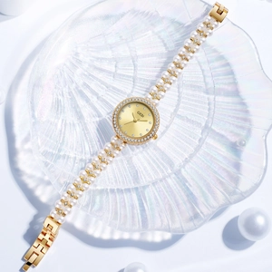 Montre de luxe GEDI pour femme avec lunette dorée diamants et bracelet élégant en perles