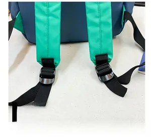Detail of adjustable green shoulder strap with black buckle on contrast school backpack