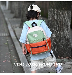 Outdoor shot of a kids color-block backpack with adjustable straps and mountain logo