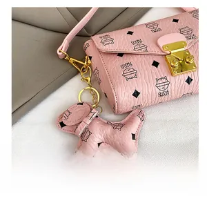 Détail du sac à main en cuir rose avec imprimé chat mignon et fermoir doré brillant