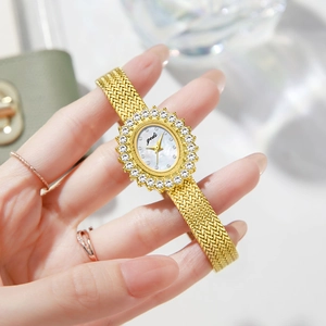 Elegant gold oval watch with crystal bezel and pearl dial on milanese mesh strap