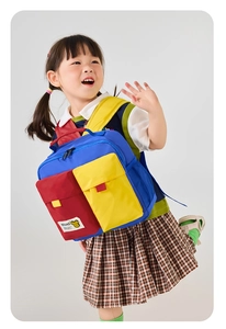 Kid's nylon backpack with vibrant red, yellow, and blue color-block design and side pockets