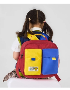 Rear view of child wearing colorful red, yellow, and blue nylon backpack with mesh side pocket