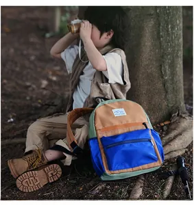 Outdoor scene of a child wearing a color-block school backpack with large capacity