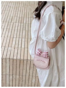 Detail of pink crossbody bag for kids featuring a red plaid bow and cat pattern