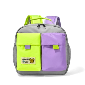 Front detail of kids backpack showing grey nylon fabric with green and purple pockets