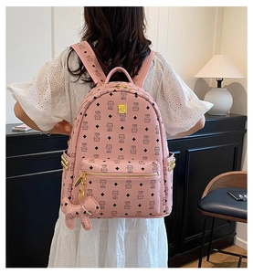 Détail d'un sac à dos en cuir rose avec imprimés chat et poches latérales cloutées