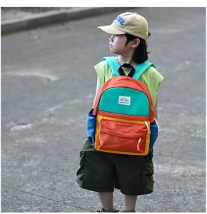 Detail view of colorful contrast stitch backpack with MOUNTAINS label for kids