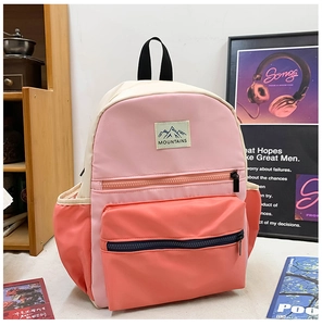Detail of color-block school backpack with MOUNTAINS logo and side storage pockets