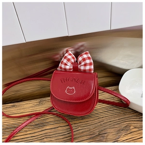 Detail of red PU leather kids crossbody bag featuring a plaid bow and cat face design