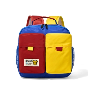 Detail view of colorful kids backpack with dual front pockets and yellow bear emblem