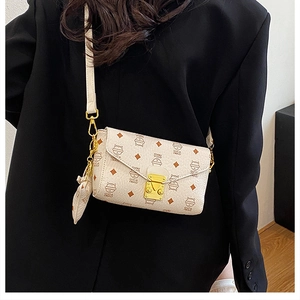 Détail du sac enveloppe imprimé chat avec fermoir doré et pendentif cœur assorti