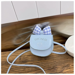 Detail of light blue kids crossbody bag featuring checkered bow and cat embroidery