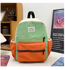 Close-up of color-block nylon backpack with mountains logo and side elastic pockets