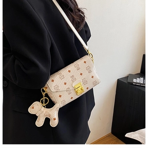 Détail du sac enveloppe crème avec imprimés de chats et fermoir métallique doré élégant