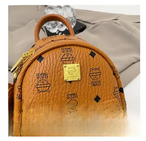 Detail shot of brown lychee leather backpack with golden nameplate and cat pattern