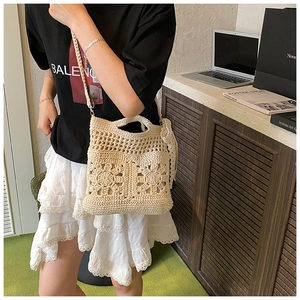 Detail of crochet floral hollow pattern on beige woven shoulder bag in a casual setting