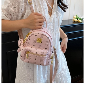 Mini pink backpack with cat print and gold zipper detail worn with lace dress