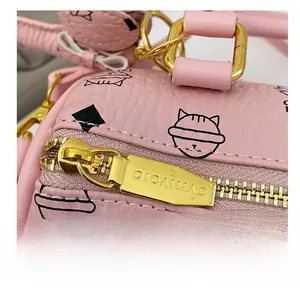 Detail of pink pebbled leather handbag with cute cat print and premium gold zipper