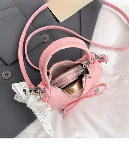 Detail of pink mini handbag showing interior capacity for makeup and white lace bow