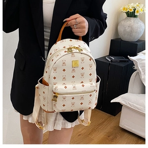 Close-up of cute bear printed travel backpack with golden metal logo and bear-shaped zipper