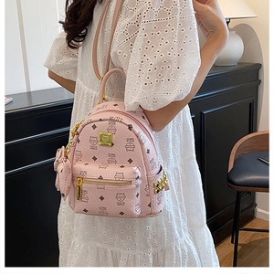 Detailed view of pink textured leather mini backpack with gold hardware and cat patterns