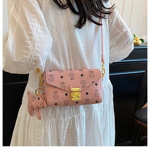 Gros plan du sac enveloppe rose avec imprimé chat, fermoir doré et détail de charme