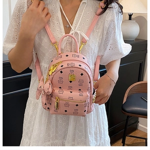 Close-up of pink leather backpack featuring cat prints and gold metal hardware detail