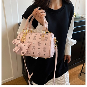 Close-up of pink boston bag featuring cat patterns and matching kitten charm detail
