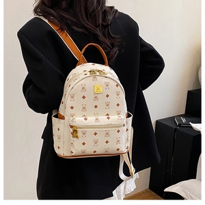 Side view of cream backpack featuring cartoon bear print and premium leather top handle