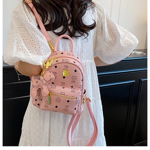 Detailed view of pink mini backpack with cat print and gold logo plate for women
