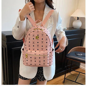 Detail of pink backpack with bear prints and elegant gold hardware in a home setting