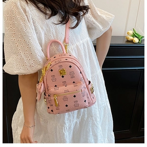 Detail view of pink leather backpack with cute cartoon prints on a female model