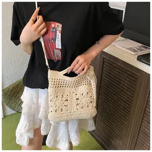 Close-up of a cream crochet crossbody bag with floral hollow-out knit patterns