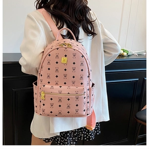 Pink travel backpack with cartoon bear print and diamond patterns worn by a model