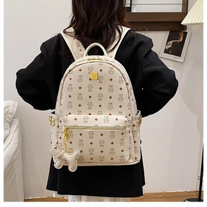 Détail du sac à dos blanc en PU avec monogramme de chat, fermetures et rivets dorés