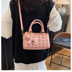 Detailed view of pink Boston bag with cat motifs and a cute puppy charm accessory
