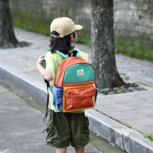 Kids colorful waterproof backpack with mountains patch in vibrant outdoor setting