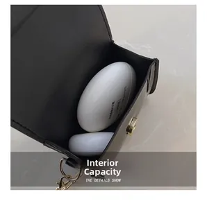 Close-up showing internal capacity of the black bow shoulder bag with chain strap