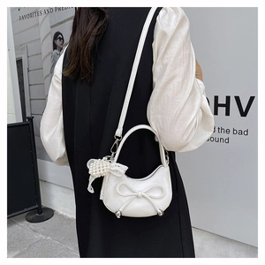 Detail of white moon bag featuring 3D bow design and pearl lace bow charm