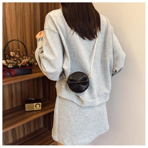 Détail du sac rond noir pour fille avec nœud décoratif et chaîne en perles