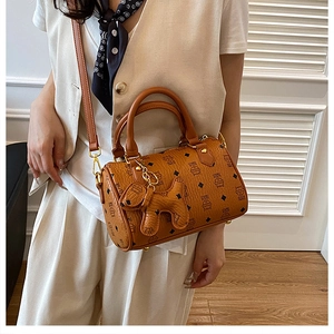 Brown vintage Boston bag with cat patterns and puppy charm shown on model