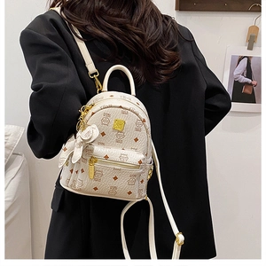 Detail of cream mini backpack with brown cat print and golden zipper hardware