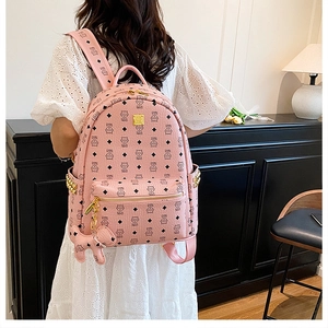 Gros plan détaillé du sac à dos en cuir rose avec motifs de chat et clous dorés