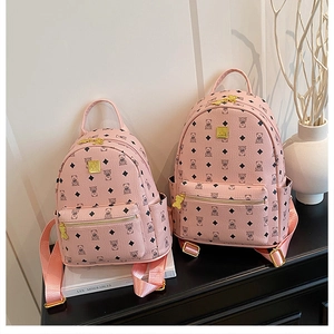 Close-up of pink leather backpacks with cute bear prints and gold logo hardware details
