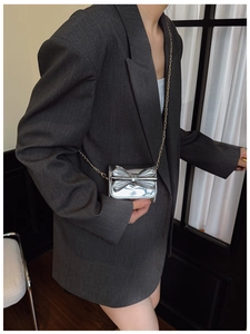Detail of silver mirror finish mini bag with bow and golden chain strap for girls